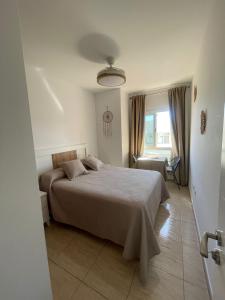 a bedroom with a bed and a chair and a window at Mar y Arena in Morro del Jable