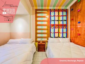 two beds in a room with a stained glass window at La Maison Homestay JB Bukit Indah in Johor Bahru