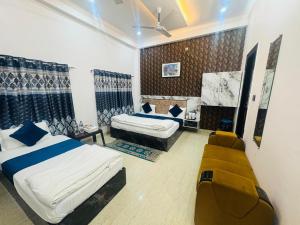 Un dormitorio con dos camas y un sofá. en Shri Radhe Radhe Guest House In-front of Ram Janam Bhumi Main Gate Opposite 200 Meter Fully AC All Rooms, en Ayodhya