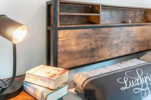 a bedroom with a bed and a lamp and books at Ferienhaus Behrends in Emden +13 photos