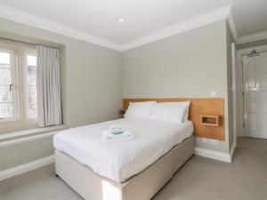 a white bedroom with a bed with a tray on it at Harcombe Heights at Harcombe House in Newton Abbot