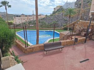 a bench sitting in front of a swimming pool at Laurent's house - ATTC International Vacations in Isla del Fraile