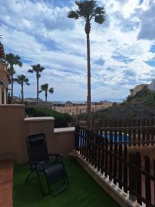 a balcony with two chairs and a palm tree at Laurent's house - ATTC International Vacations in Isla del Fraile