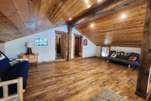 a living room with a couch and wooden ceilings at Lakefront on Lake Shore in Joseph
