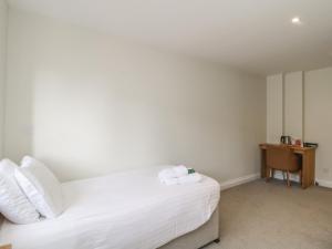 a bedroom with a white bed and a desk at Harcombe House Rooms - First Floor Single in Newton Abbot