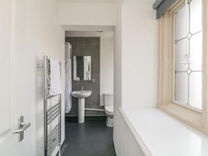 a white bathroom with a sink and a toilet at Harcombe House Rooms - First Floor Single in Newton Abbot +27 photos