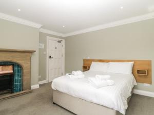 a bedroom with a bed with two towels on it at Harcombe House Rooms - First Floor King in Newton Abbot