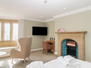 a living room with a fireplace and a television at Harcombe House Rooms - First Floor King in Newton Abbot +28 photos