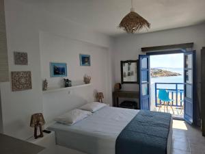 a bedroom with a bed and a view of the ocean at Vrahos Rooms - Studios in Alopronia