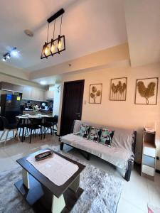a living room with a couch and a table at Bayview near CCP, PICC, Airport, MOA, Okada at Radiance in Manila +8 photos