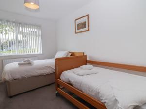 a bedroom with two beds and a window at Harcombe House Accessible Pet Free Bungalow Sleeps 6 in Newton Abbot +37 photos