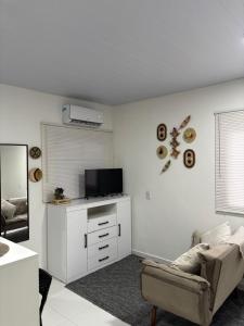 a living room with a couch and a tv at Apartamento capital in Belém