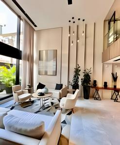 a living room with white furniture and large windows at Fantastic, Studio com Ar Cond. e Wi-fi in Curitiba