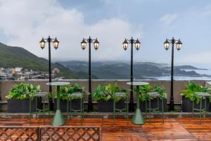 a group of tables and chairs on a balcony at Pet Friendly Nostalgic Inn in Jiufen