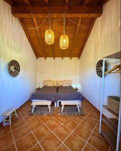 a bedroom with a bed and two benches in a room at Monte da Carrasqueira in Santiago do Cacém +30 photos