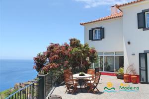 卡列塔OurMadeira - Casa do Júlio, Calheta beach view的房屋前设有带桌椅的天井。