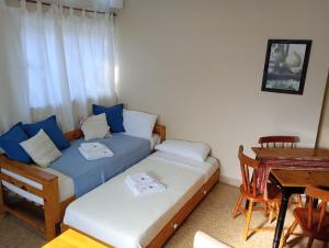 a bedroom with two beds and a table and a desk at Temporario Del Centro in Paso de los Libres
