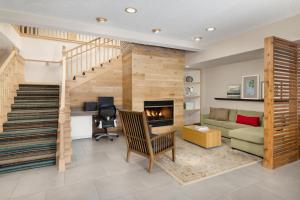 a living room with a staircase and a fireplace at Country Inn & Suites by Radisson, Springfield, OH in Springfield