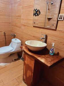 a bathroom with a sink and a toilet on a wooden counter at Rockwood Heights in Khaira Gali +16 photos