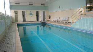 a large swimming pool with blue water in a building at Schwarzwaldstübchen "Altas Montañas" mit Schwimmbad in Baiersbronn