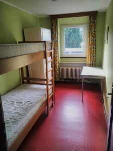 ein Zimmer mit zwei Etagenbetten und einem Fenster in der Unterkunft Haus Vinzenz Amel in Amel