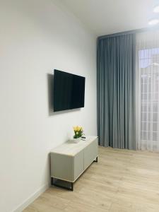 a living room with a tv on a wall at RINI Apartment in Muruntau