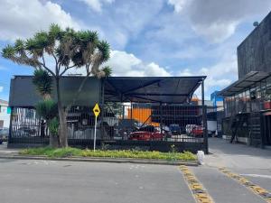 a building with a palm tree in a parking lot at Yachi Hostel et Kuyay in Bogotá