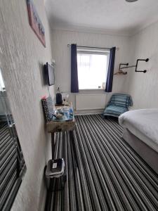 a hotel room with a bed and a window at Westbrook Lodge Guest House in Margate