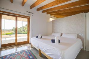 a bedroom with two beds and a large window at Can Cadernera by Rentallorca in Can Picafort +28 photos