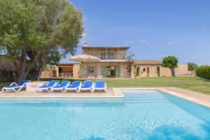 a swimming pool with lounge chairs and a house at Can Cadernera by Rentallorca in Can Picafort