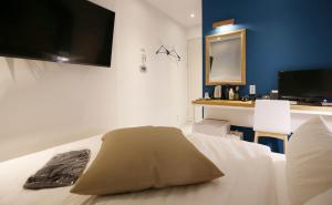 a bedroom with a bed with a tv on the wall at NU Hotel in Cheonan