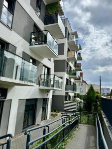 a building with balconies and a walkway in front of it at Just Unique black in Poznań