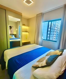 a bedroom with a large bed and a window at REFUGiO Studio novo c/cama Queen e Ar Condicionado in Curitiba