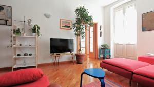 een woonkamer met een rode bank en een flatscreen-tv bij The Lemon House in Cagliari