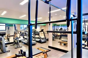 a gym with treadmills and elliptical machines at VERSáTIL - Apto de 1 quarto in Curitiba