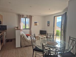 salon ze szklanym stołem i krzesłami w obiekcie Charmant petit logement à 3 kms de la plage w mieście Belgodère +30 zdjęć