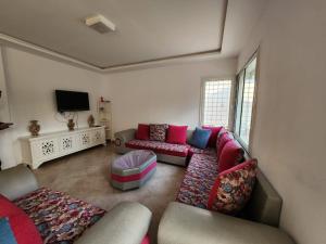 a living room with a couch and a tv at Villa la familia in Hammamet Nord