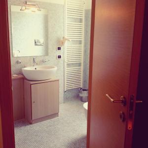 a bathroom with a sink, toilet, and bathtub at Hotel Paclà in Avola