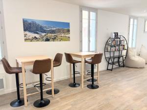 a room with two tables and chairs and a shelf at Lourdes Backpackers in Lourdes +46 photos
