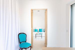 a room with a mirror and a blue chair at Casa Michela by Elite Villas in Capri