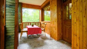 un tavolo con sedie in una stanza con pareti in legno di Abant Korudam bungalov butik otel ad Abant