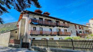 an old building with balconies and a fence at Appartamento Ortigara 16 - Affitti Brevi Italia in Oulx