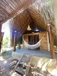a hammock hanging from a thatched hut with a chair at Pal Mar our beach house  +23 photos