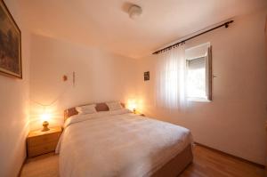 a bedroom with a large bed and a window at Apartment Agata in Splitska