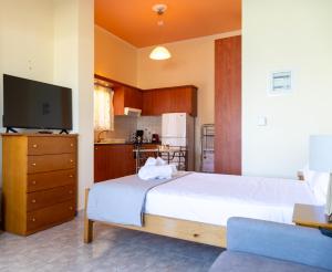a bedroom with a large white bed and a television at InstaView Tolo 2 in Tolo