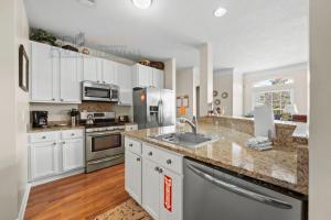 a large kitchen with white cabinets and a sink at Legacy Villa 704 in Gulfport