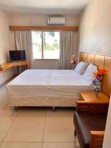 a bedroom with a large bed and a window at Plaza Flat in Ribeirão Preto