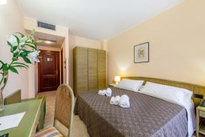 Ένα ή περισσότερα κρεβάτια σε δωμάτιο στο Rina Hotel