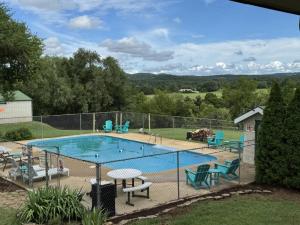 a swimming pool with chairs and a fence around it at Carlton Marion Inn in Yellville