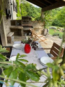 Una mesa con platos y un jarrón rojo encima. en Bolara 60: the Cottage, en Grožnjan 40 fotos más